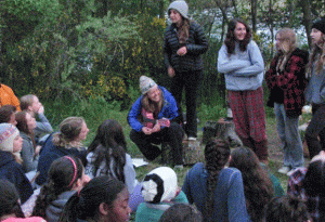Singing and playing guitar while leading a outdoor education program